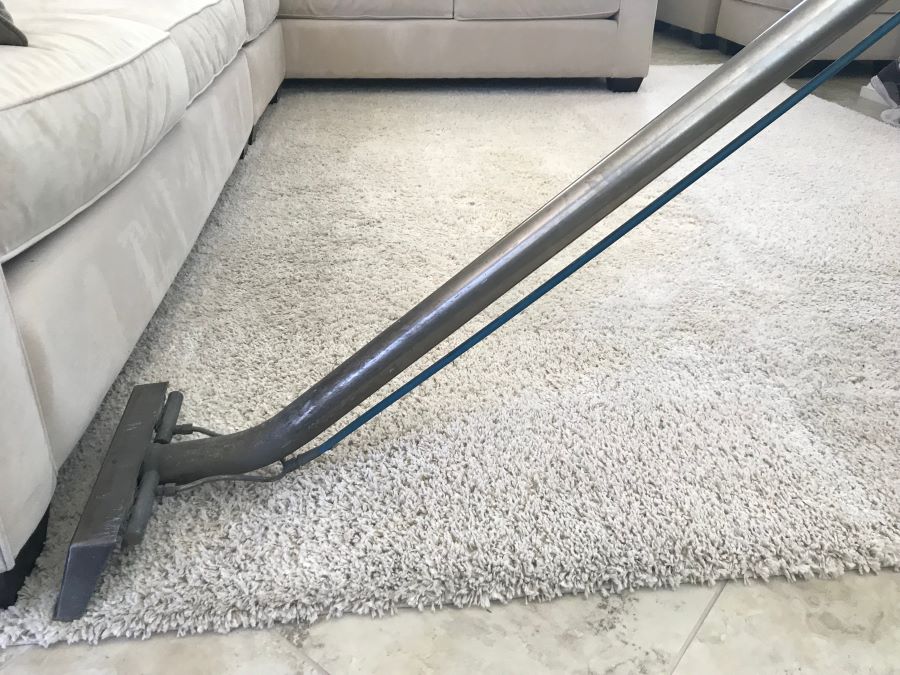 a man is using a shampooer to steam clean a white 2023 11 27 05 03 16 utc