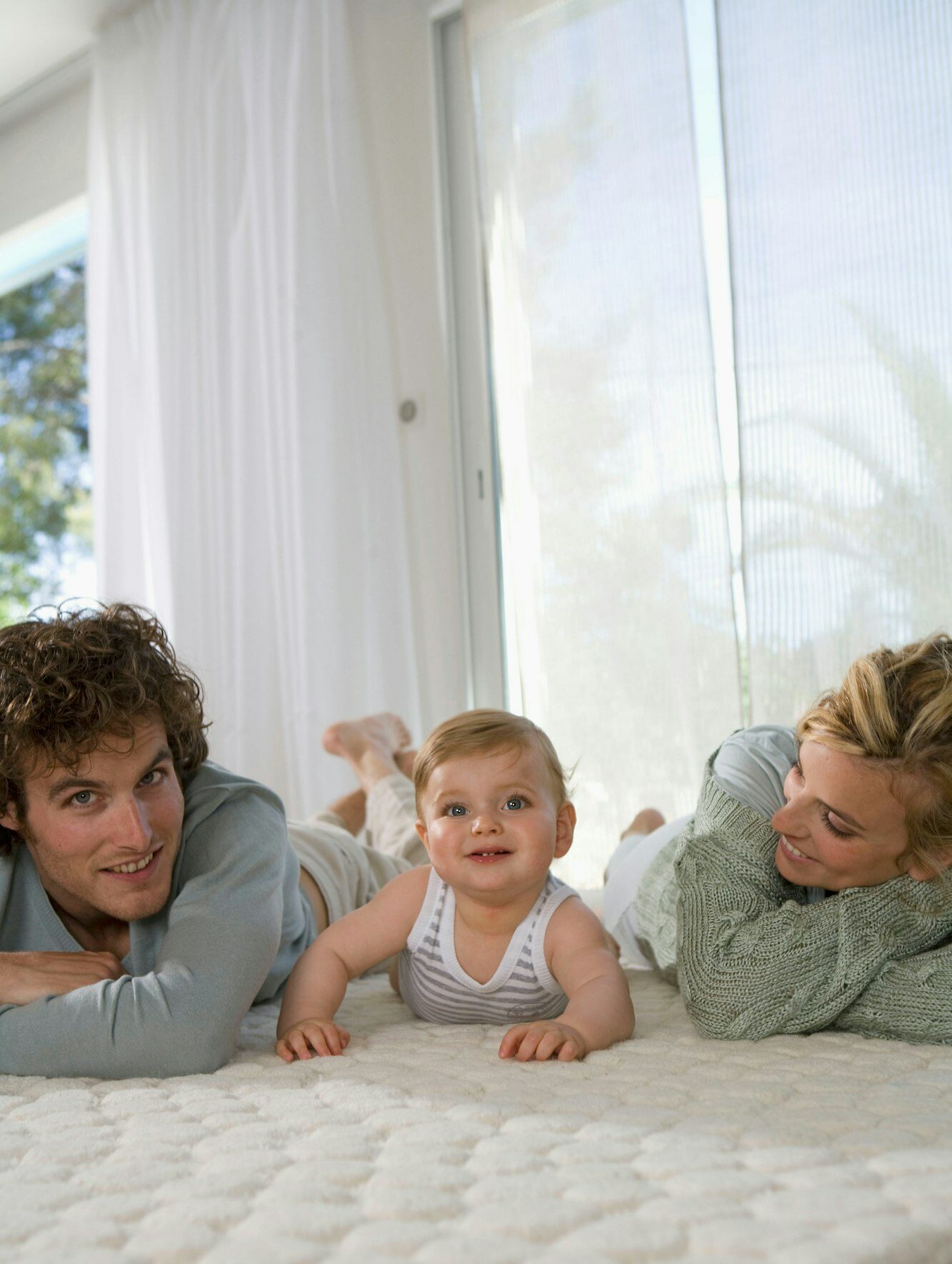 Parents with baby happy on carpet